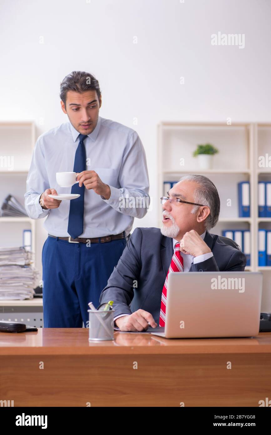 Old boss and young employee in the office Stock Photo Alamy
