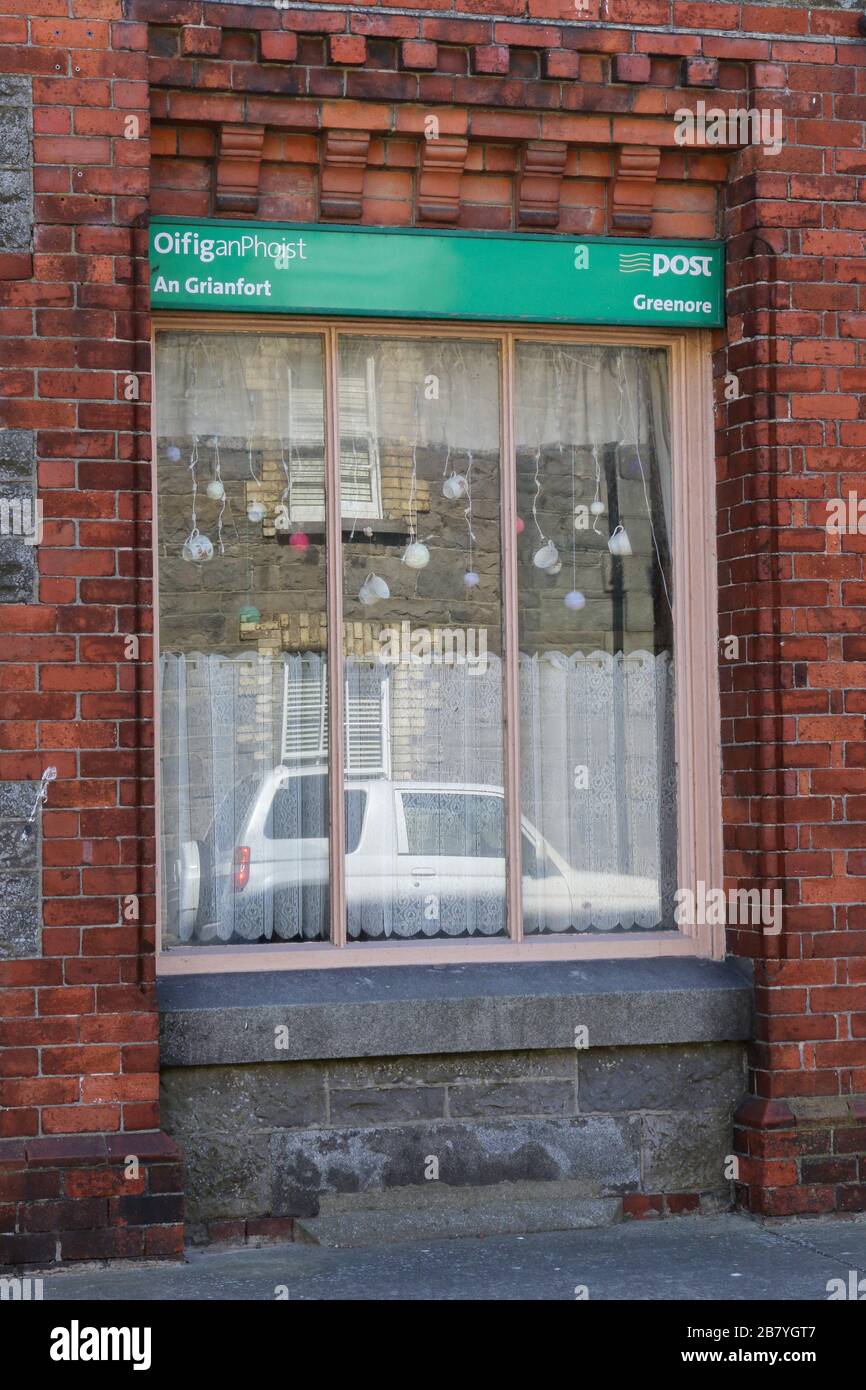 Front window and façade of the post office in Greenore, County Louth, a small rural village post office beside the Carlingford Lough port. Stock Photo