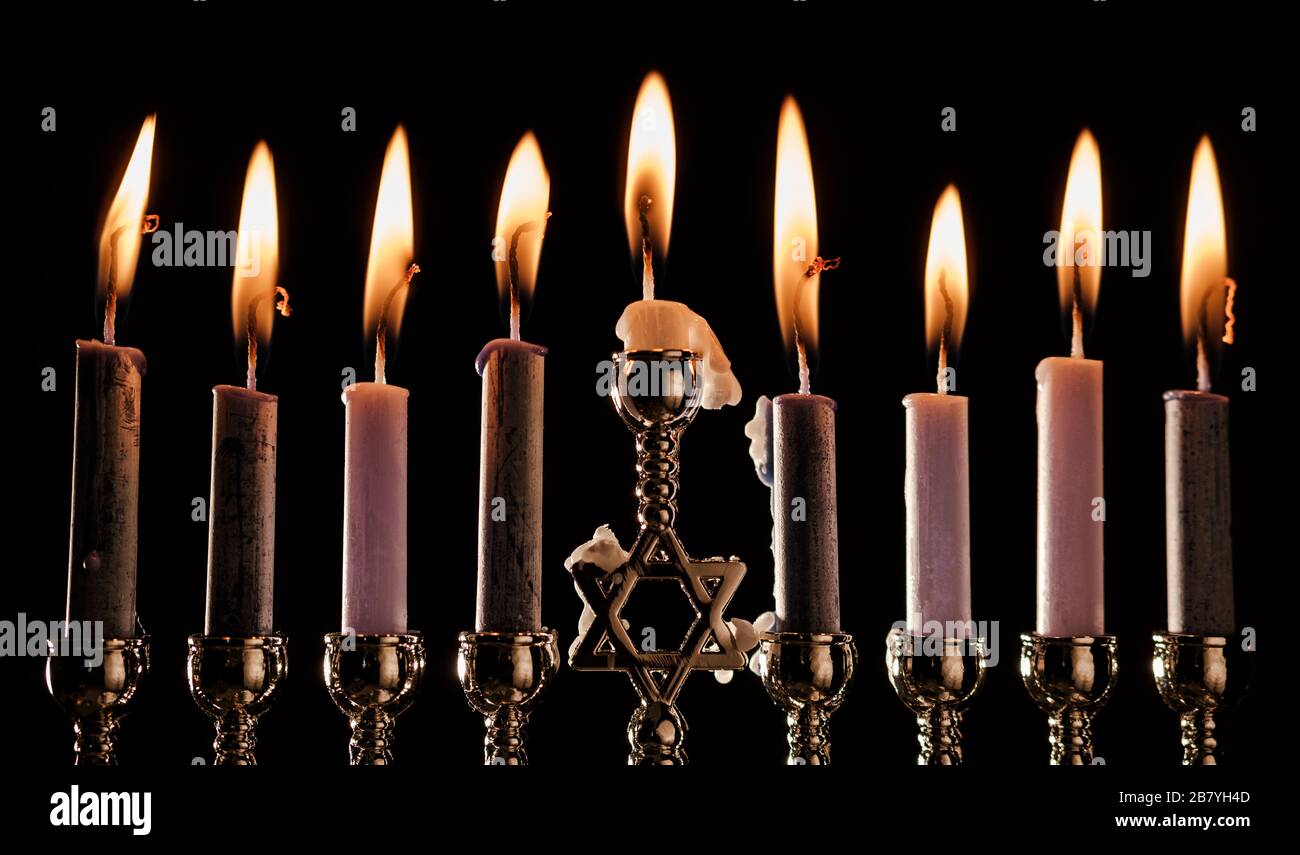Lit candles in menorah Stock Photo Alamy