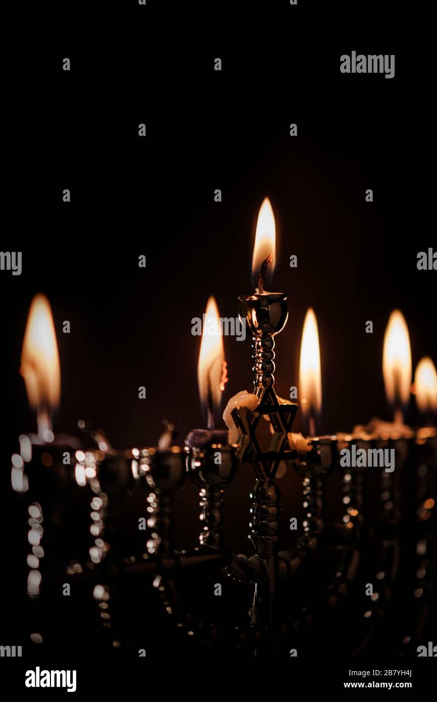 Lit candles in menorah Stock Photo
