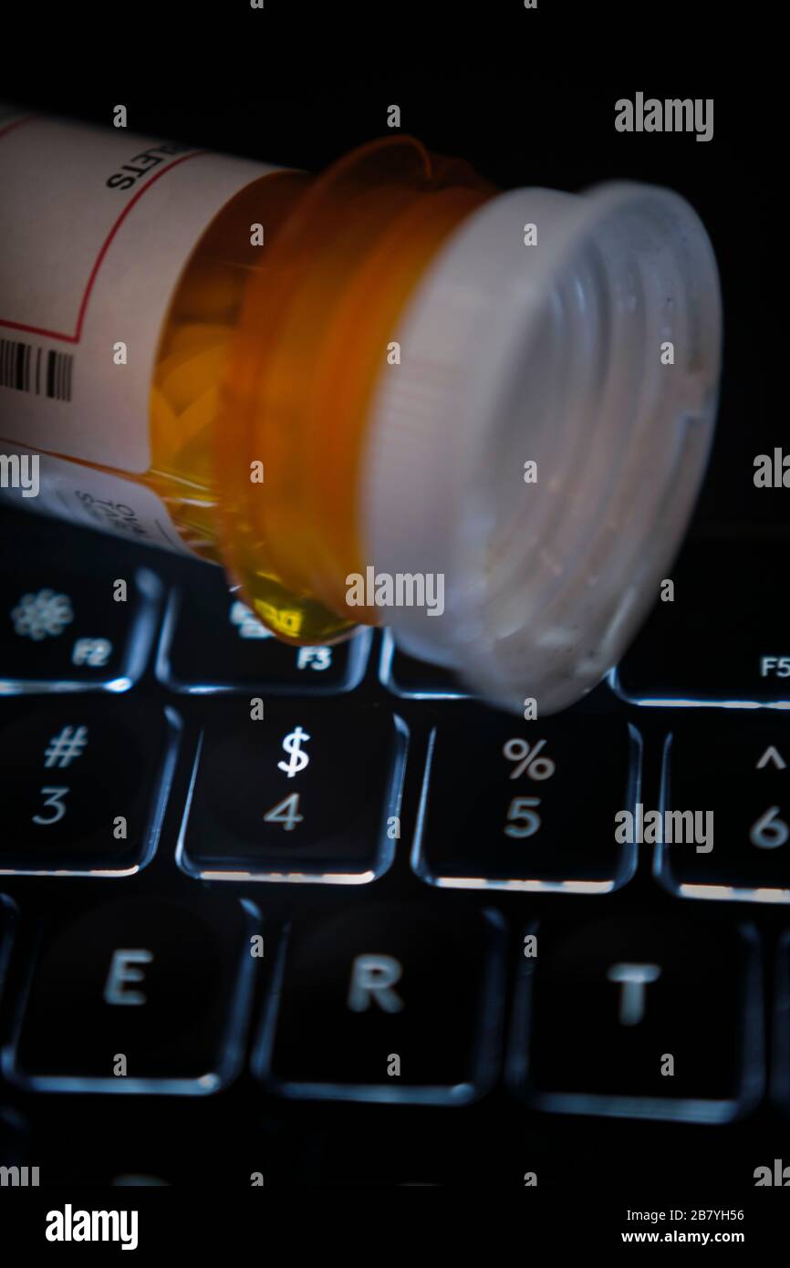 Pill bottle on computer keyboard Stock Photo Alamy