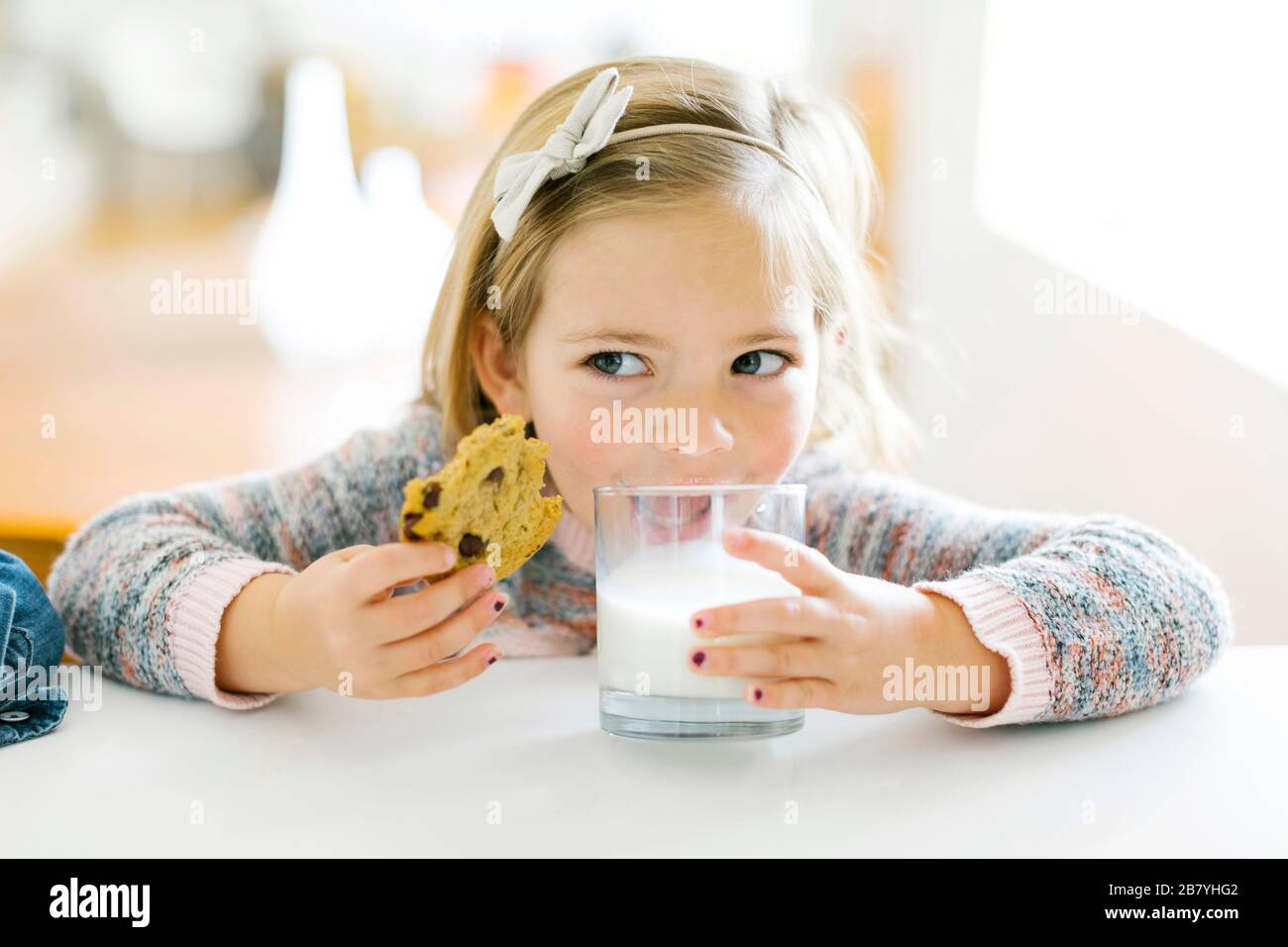 Girl eating milk and cookies Stock Photo Alamy