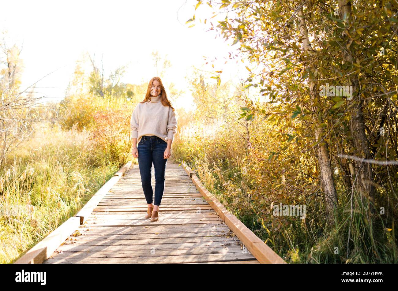 Smiling woman standing on forest boardwalk Stock Photo