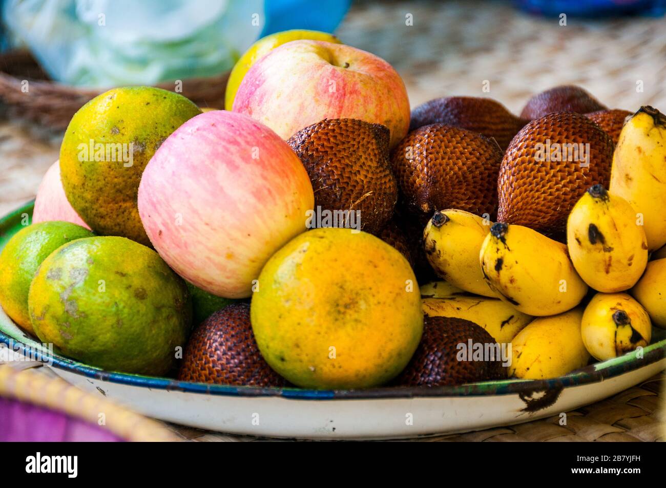 A fruit bowl of salak (snakefruit), lady finger bananas, apples and oranges on Bali. Stock Photo