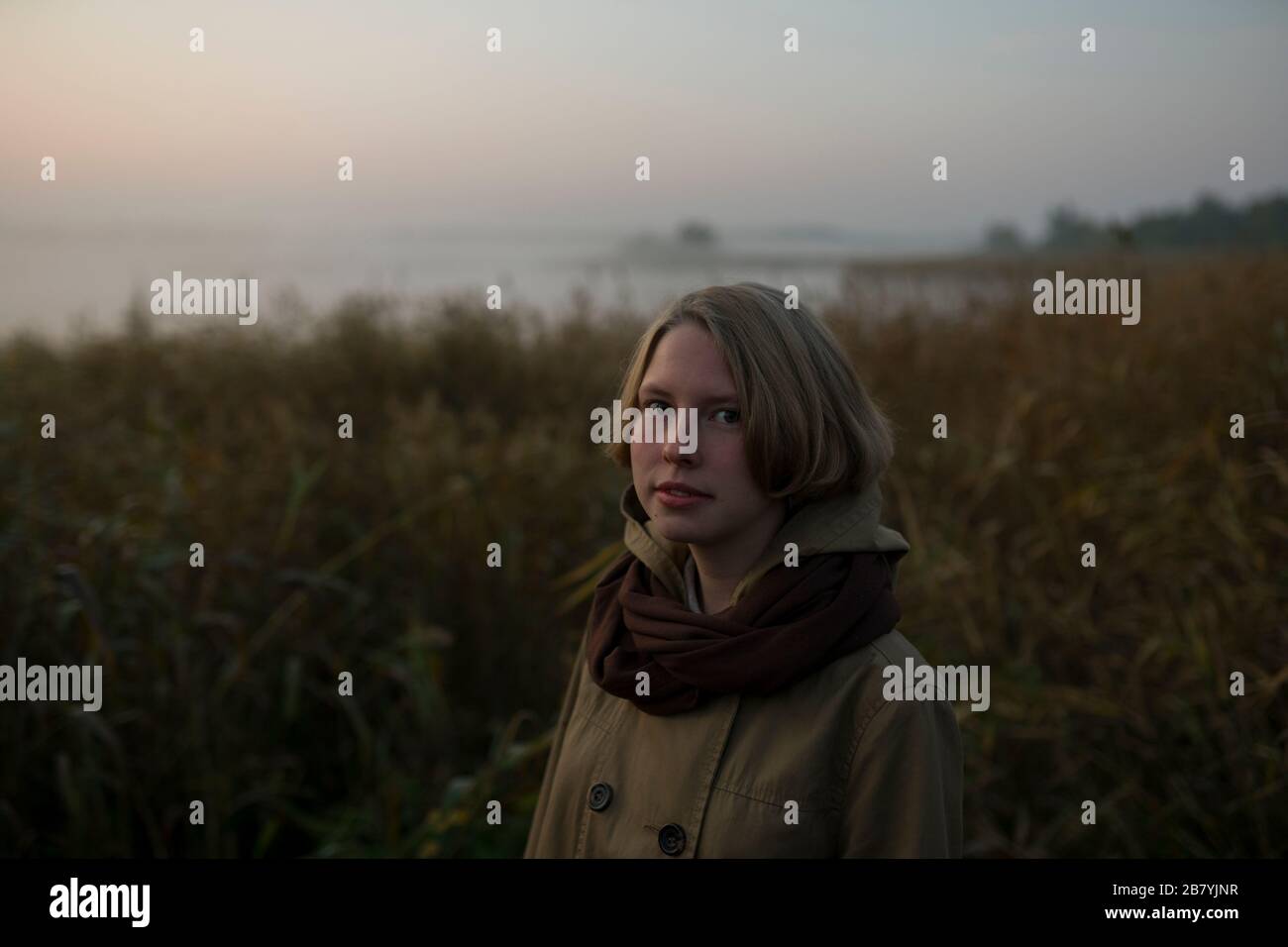 Young woman in field at sunset Stock Photo