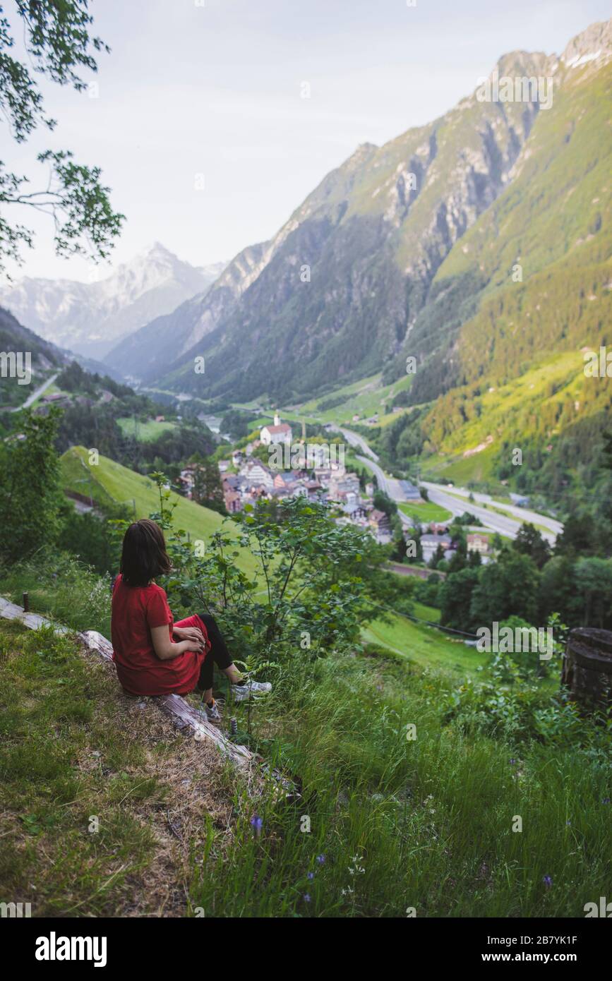 Young woman sitting on mountain above valley Stock Photo