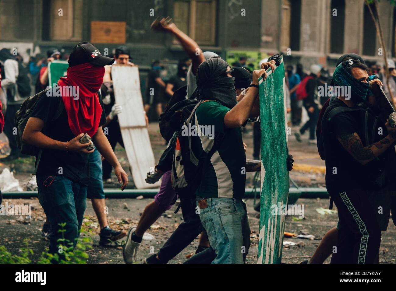 SANTIAGO, CHILE-NOVEMBER 8, 2019 - Protesters protect themselves from riot police with improvised shields during the protests against the government o Stock Photo