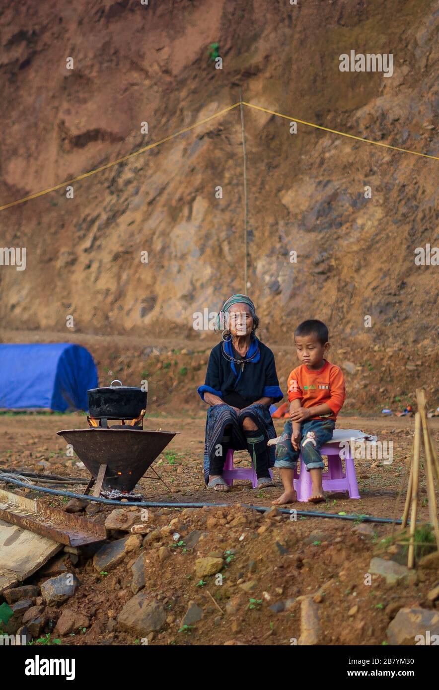 Sa pa, Vietnam-Sep 22, 2017. An old Hmong lady sat with her grandson in front of the fire on Sep 22, 2017 in Sa pa, North Vietnam Stock Photo