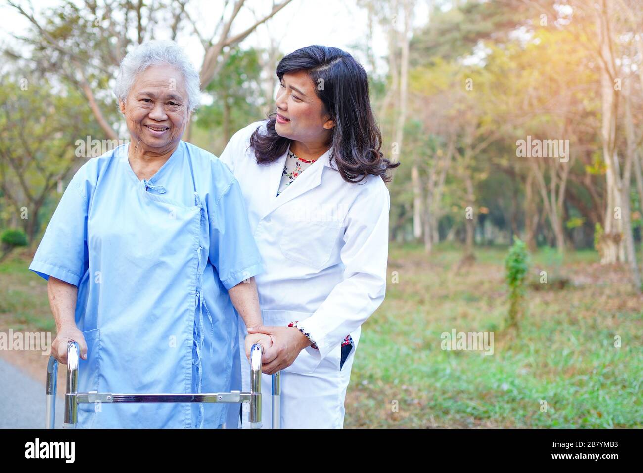 Doctor help and care Asian senior or elderly old lady woman use walker ...