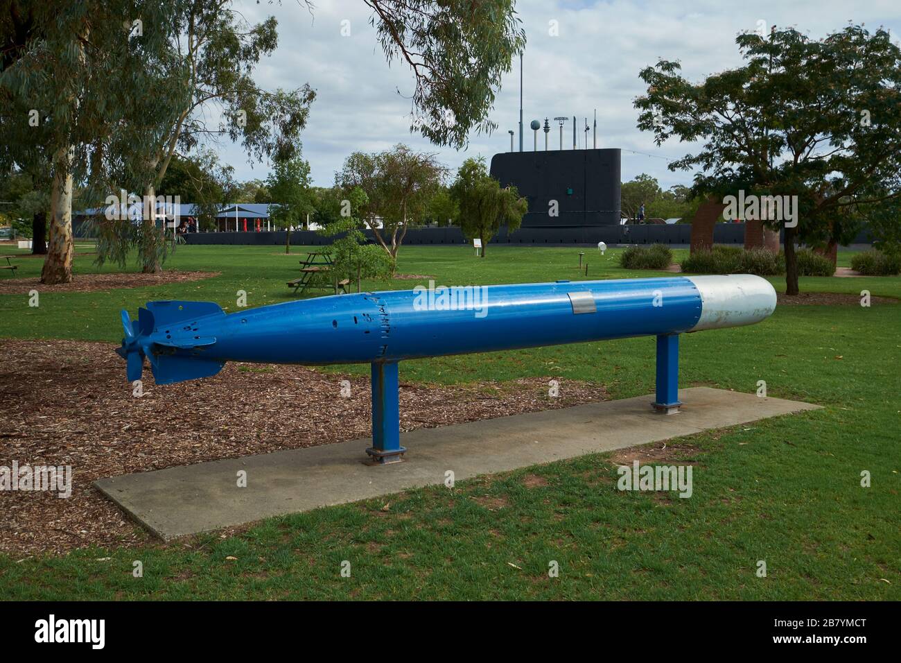 A torpedo with the actual HMAS Otway submarine in the background. At the Commander Holbrook park in Hollbrook, NSW, Australia. Stock Photo