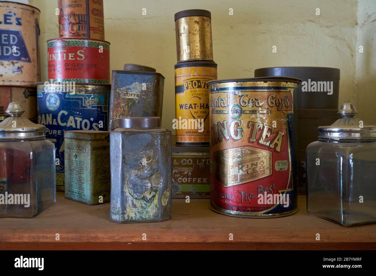 A stack, stillife arrangement of various old, rusty dry goods, food tins and bottles. At the Woolpack Museum in Holbrook, Australia. Stock Photo