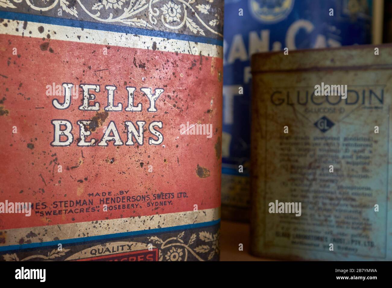 A square, old, rusty, metal tin for jelly beans. At the Woolpack Museum in Holbrook, Australia. Stock Photo