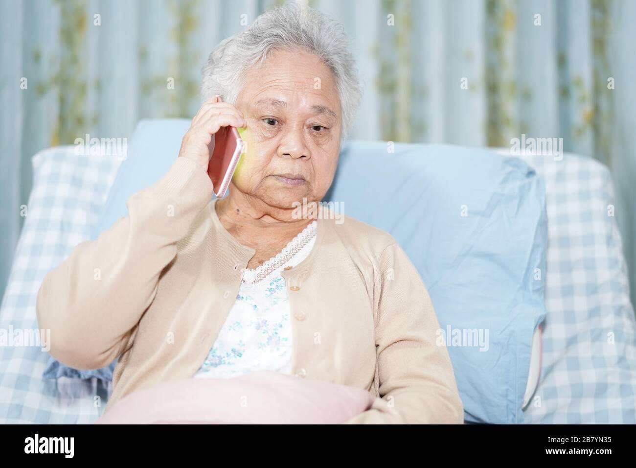 Asian senior or elderly old lady woman patient talking on the mobile phone while  sitting and happy on bed in nursing hospital ward : healthy strong me Stock  Photo - Alamy