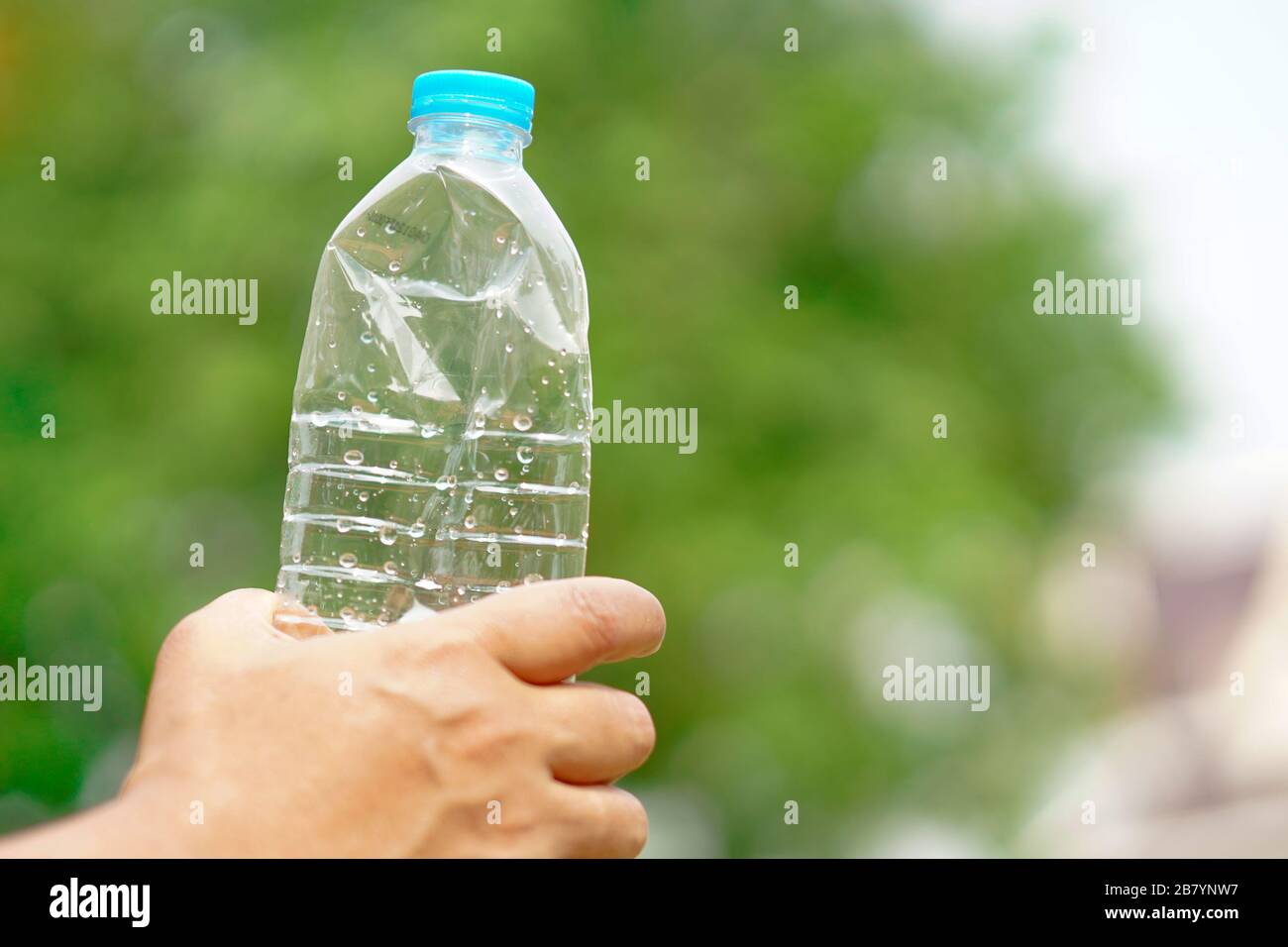 Hand squeeze empty water bottle prepare throw into the trash Stock