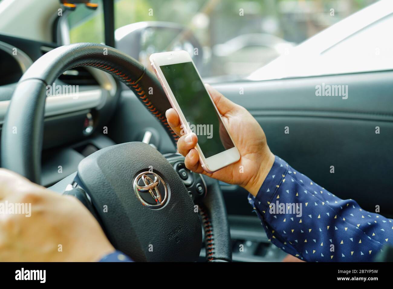 Bangkok, Thailand - February 25, 2019: Holding iPhone in toyota sienta car to communication with family and friends. Stock Photo