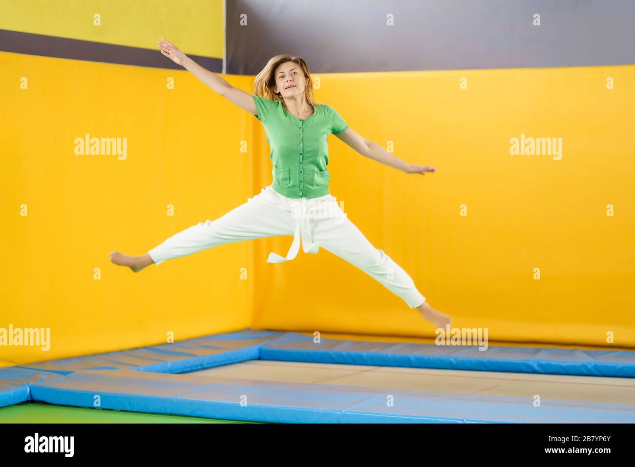 Young girl jumping on a trampoline in sport center Stock Photo - Alamy