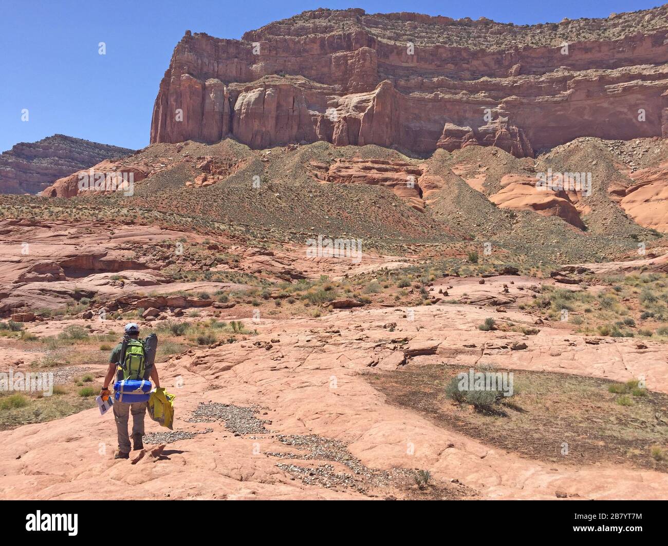 Man backpacking hiking through grand escalante staircase Reflection Canyon Arizona USA Stock Photo