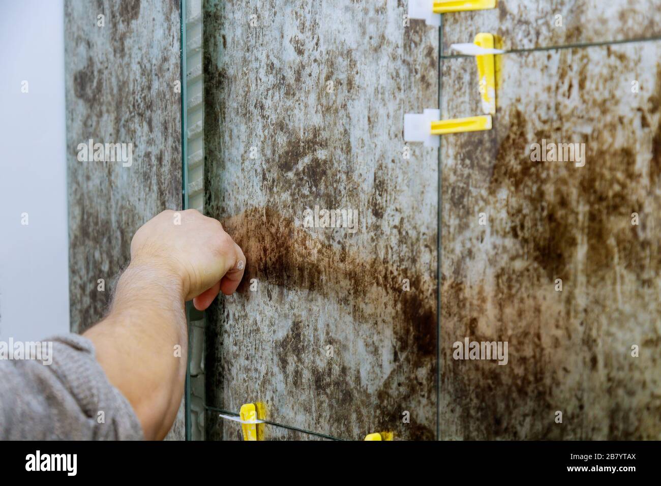 Spreading wet mortar before applying tiles on bathroom floor tile Stock