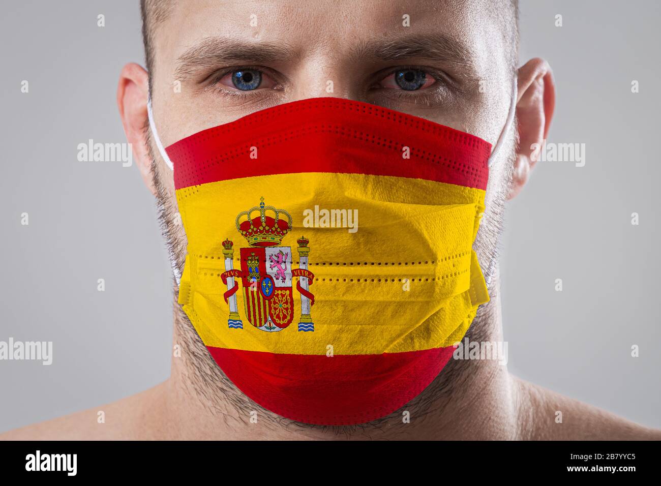 Red Mask Spain Young man with sore eyes in a medical mask painted in the colors of the ...