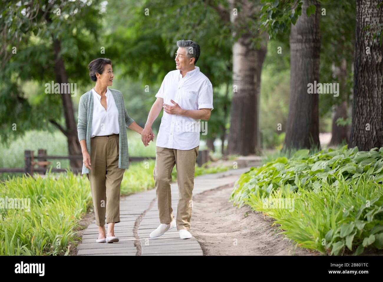 Happy senior Chinese couple walking in park Stock Photo - Alamy