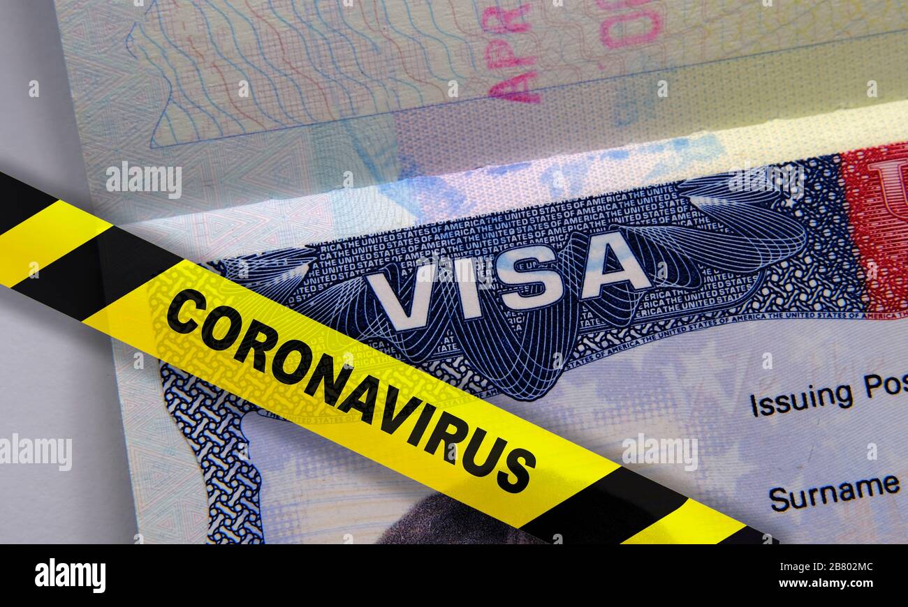Coronavirus COVID-19 quarantine stripe on top of a passport with American VISA. Concept for travel ban, epidemic in the US and global pandemic Stock Photo