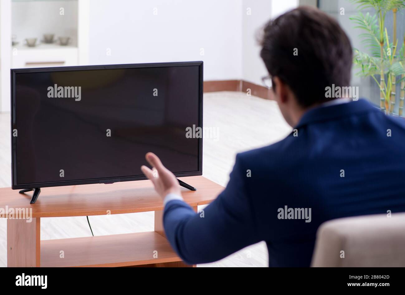 The businessman watching tv in the office Stock Photo Alamy
