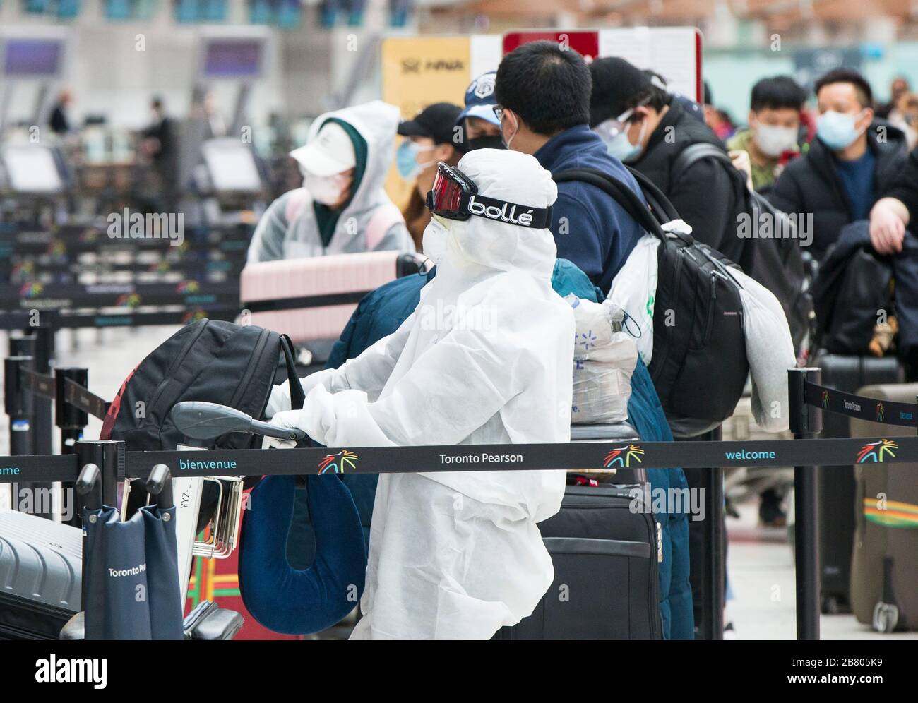 Toronto, Canada. 18th Mar, 2020. Travellers line up to check in at Terminal 3 of Pearson International Airport in Toronto, Canada, March 18, 2020. Canadian Prime Minister Justin Trudeau announced that the Canada-U.S. border will close to all non-essential travel, but shipments, trade and commerce will not be affected by the new restriction at the Canada-U.S. border. Credit: Zou Zheng/Xinhua/Alamy Live News Stock Photo