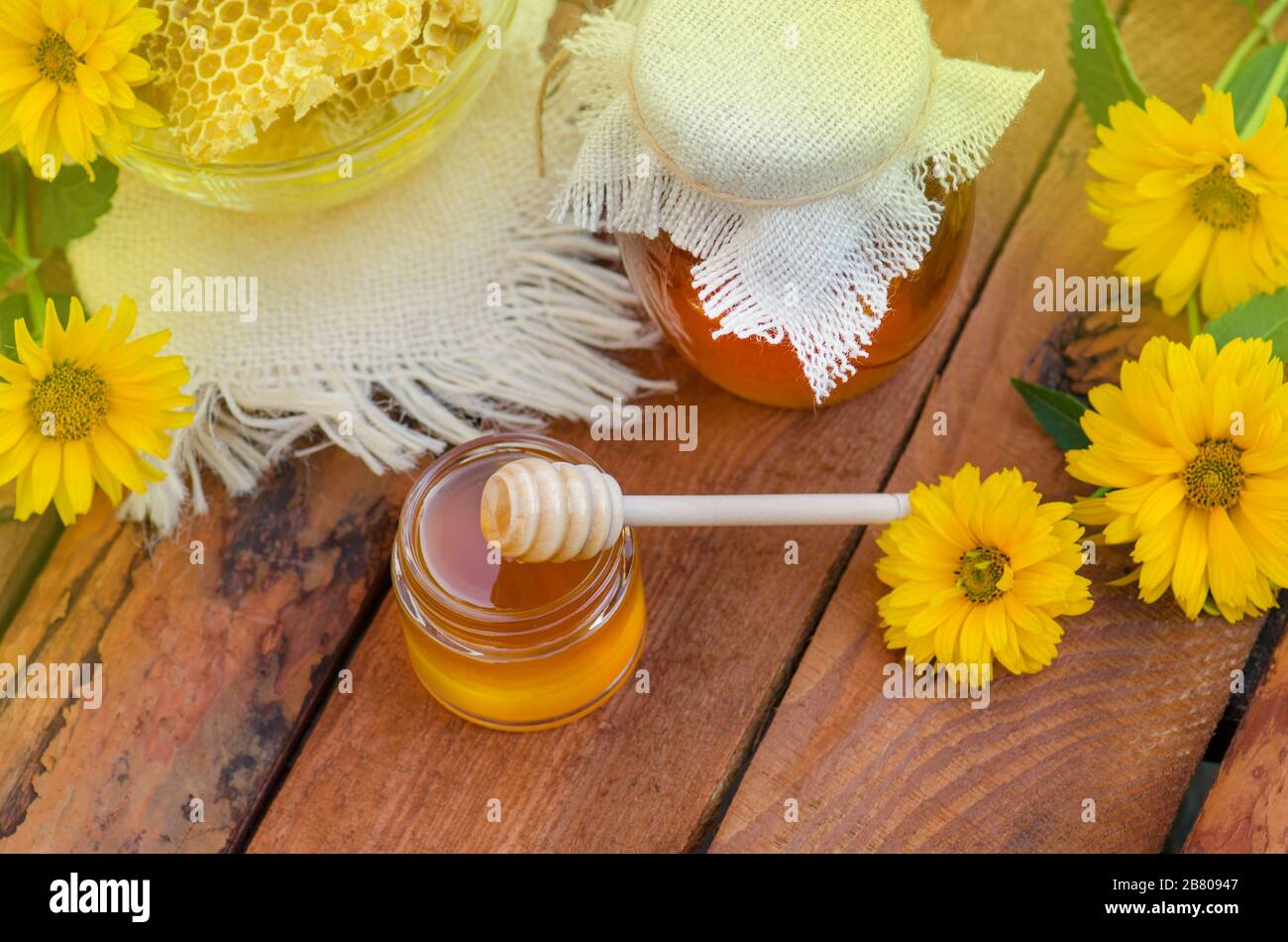 Honey jar and on wooden table. Honey jar and flowes on table