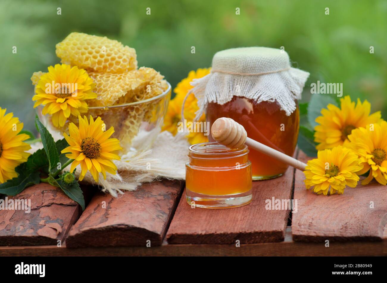 Honey jar and on wooden table. Honey jar and flowes on table