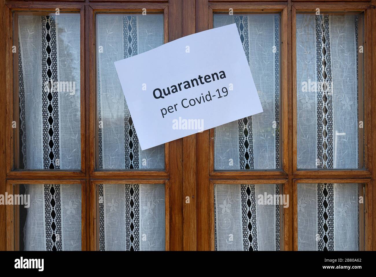 The sign Quarantine  for Covid-19 virus in Italian language on a wooden window Stock Photo