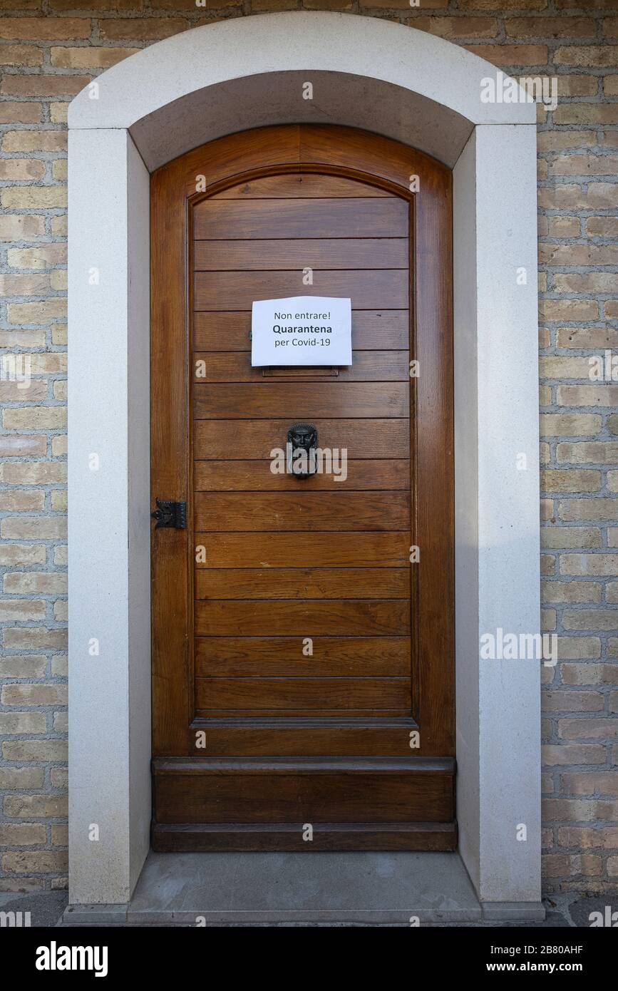 The sign No entry Quarantine  for Covid-19 virus in Italian language on a wooden entrance door Stock Photo