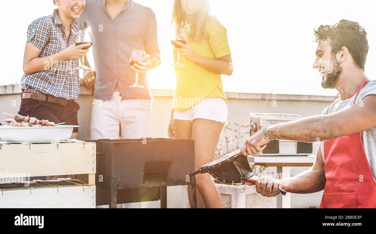 Group of young friends having fun at patio barbecue party drinking wine ...