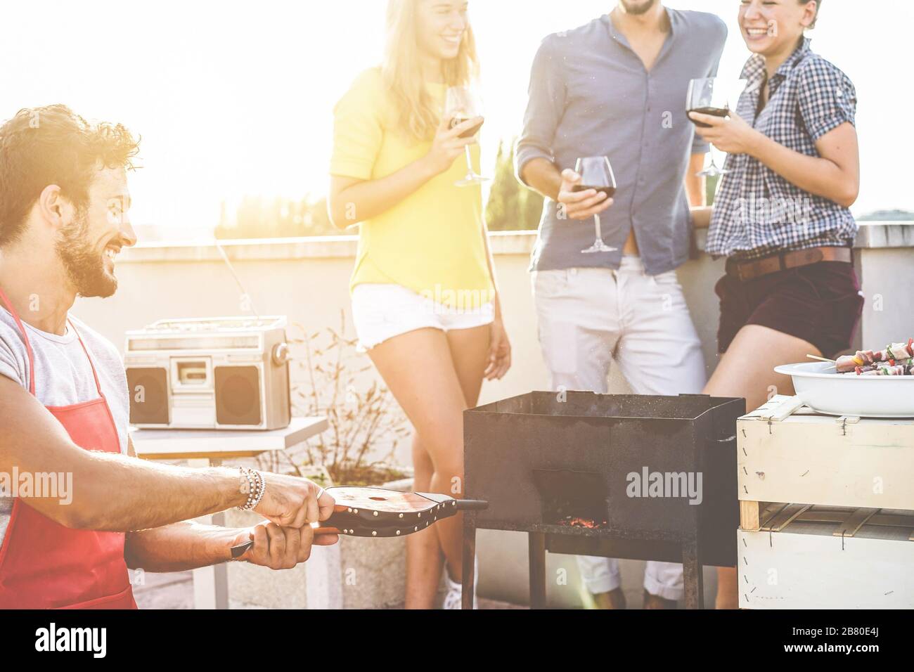 Group of young friends having fun at patio barbecue party drinking wine ...