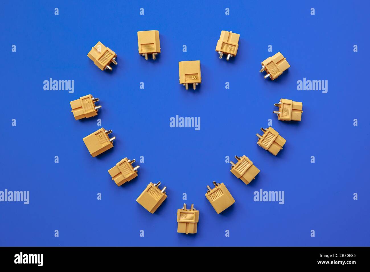 Heart made of yellow XT-60 connectors for power supply on a blue background. The heart of an electronic engineer. Stock Photo