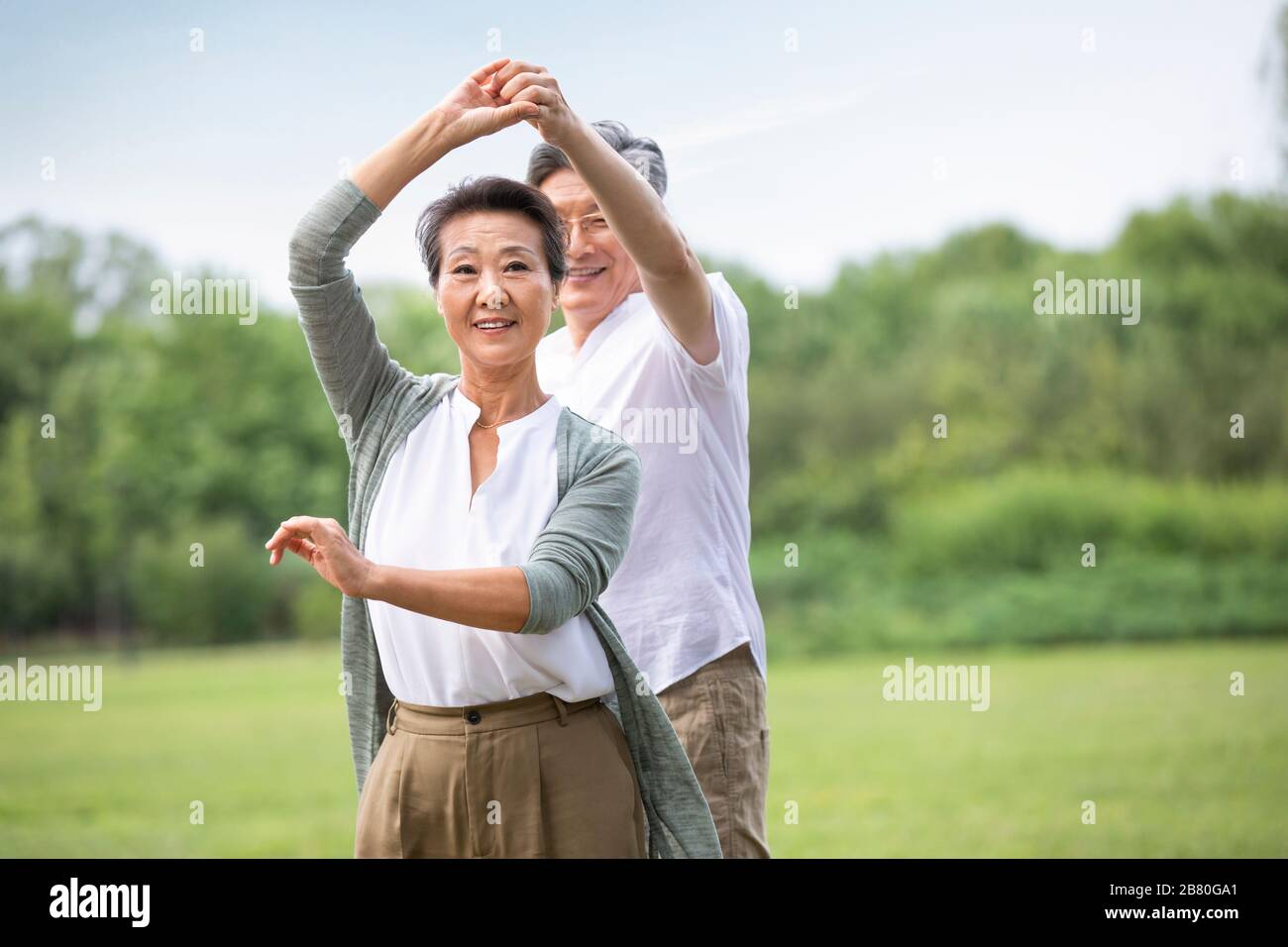 Happy senior Chinese couple dancing on grass Stock Photo - Alamy