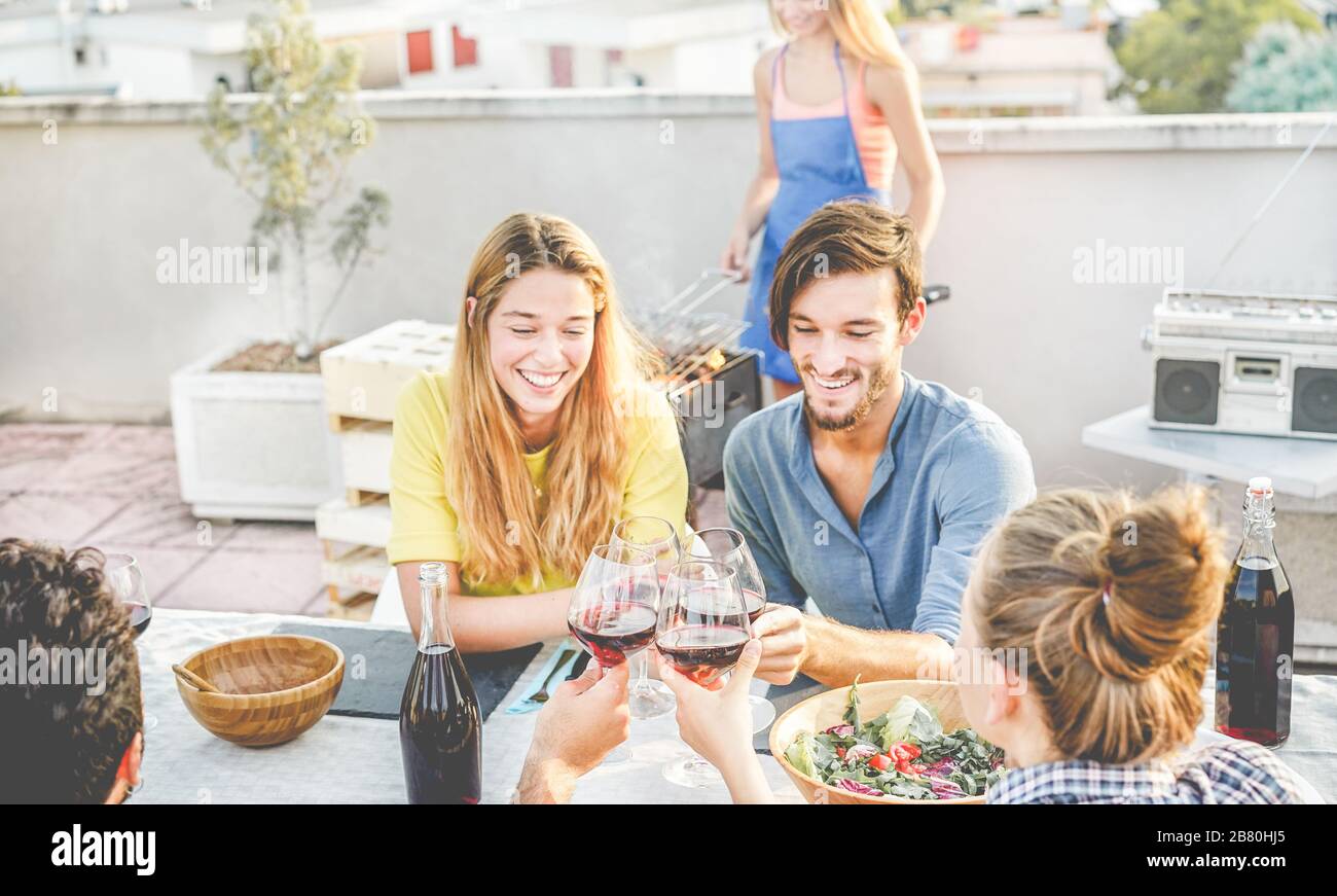 Happy friends cheering with red wine at patio barbecue party - Smiling ...