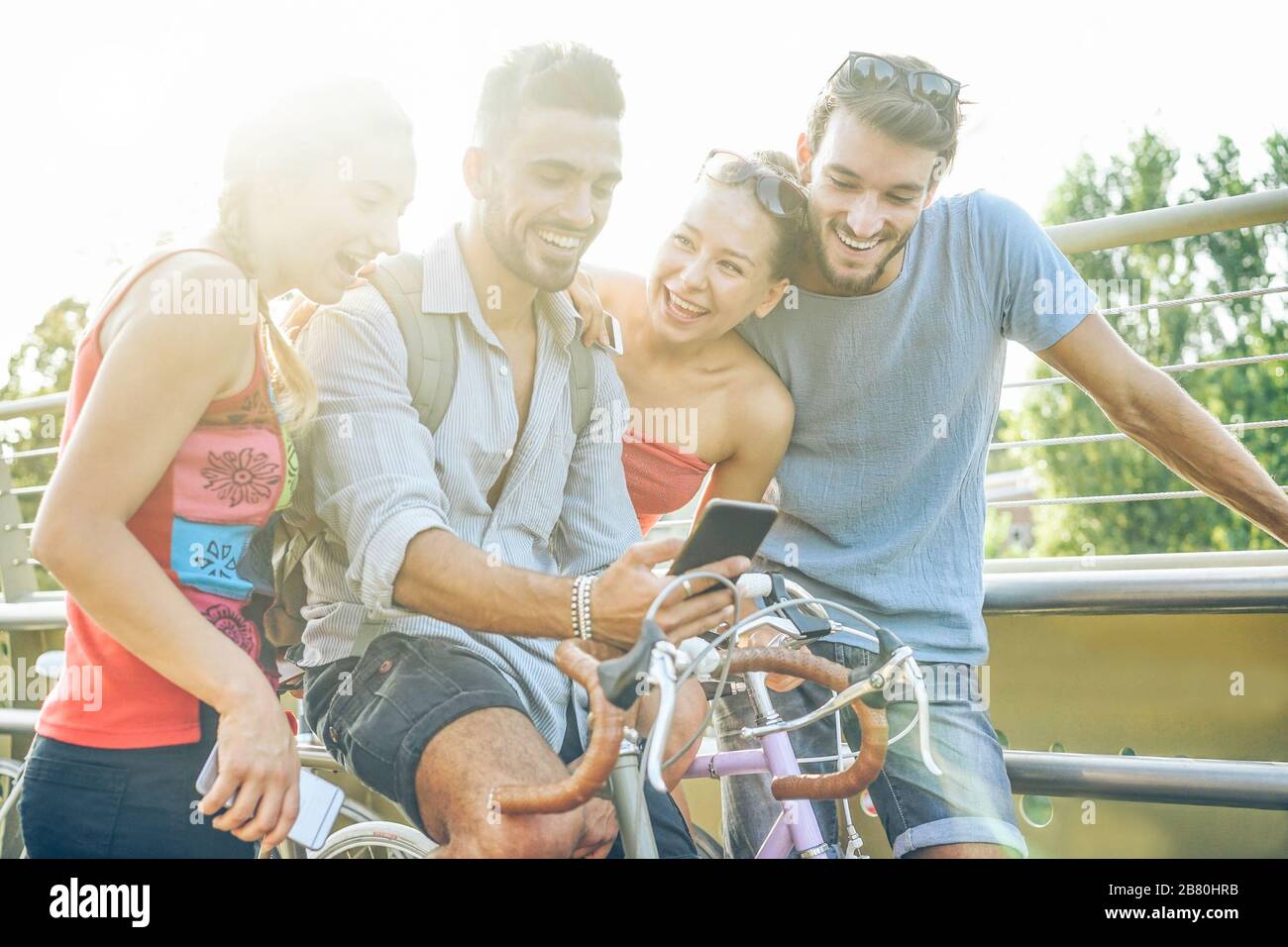 Happy friends using smartphone for watching videos outdoor Young people sharing media in new