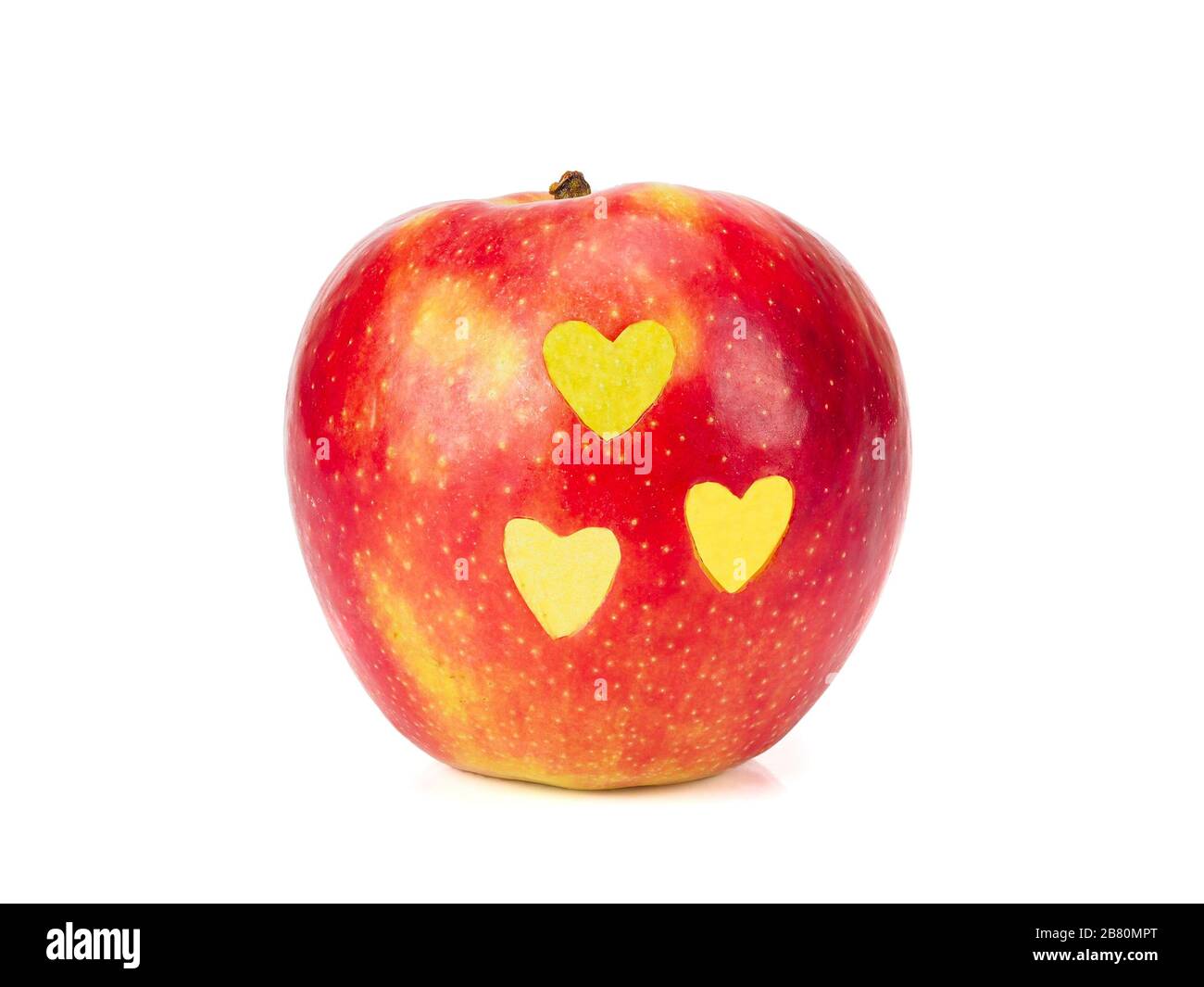 Fresh red apple with yellow hearts on its side isolated on white Stock Photo