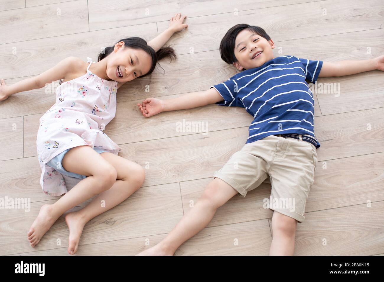 Happy Chinese sibling lying on floor Stock Photo Alamy