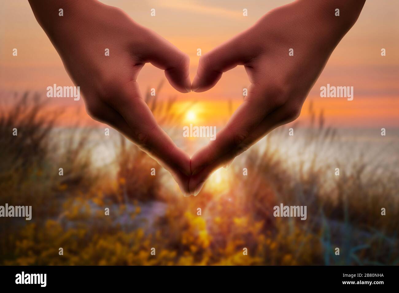 Heart shape with hands in the sunrise. A statement for a good life. Stock Photo