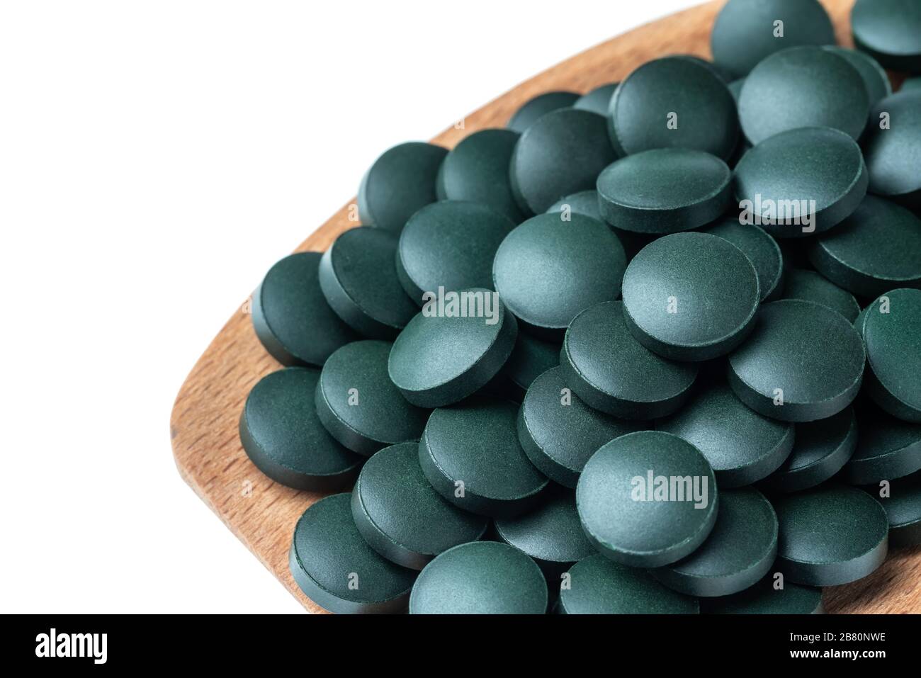 Vitamin and mineral supplements for vegetarians spirulina in tablets in a wooden spoon, close-up Stock Photo