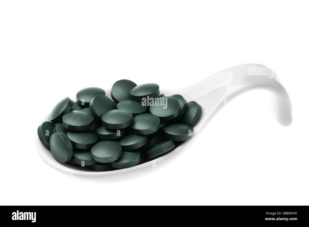 Vitamin and mineral supplements for vegetarians spirulina in tablets in a ceramic spoon, close-up Stock Photo