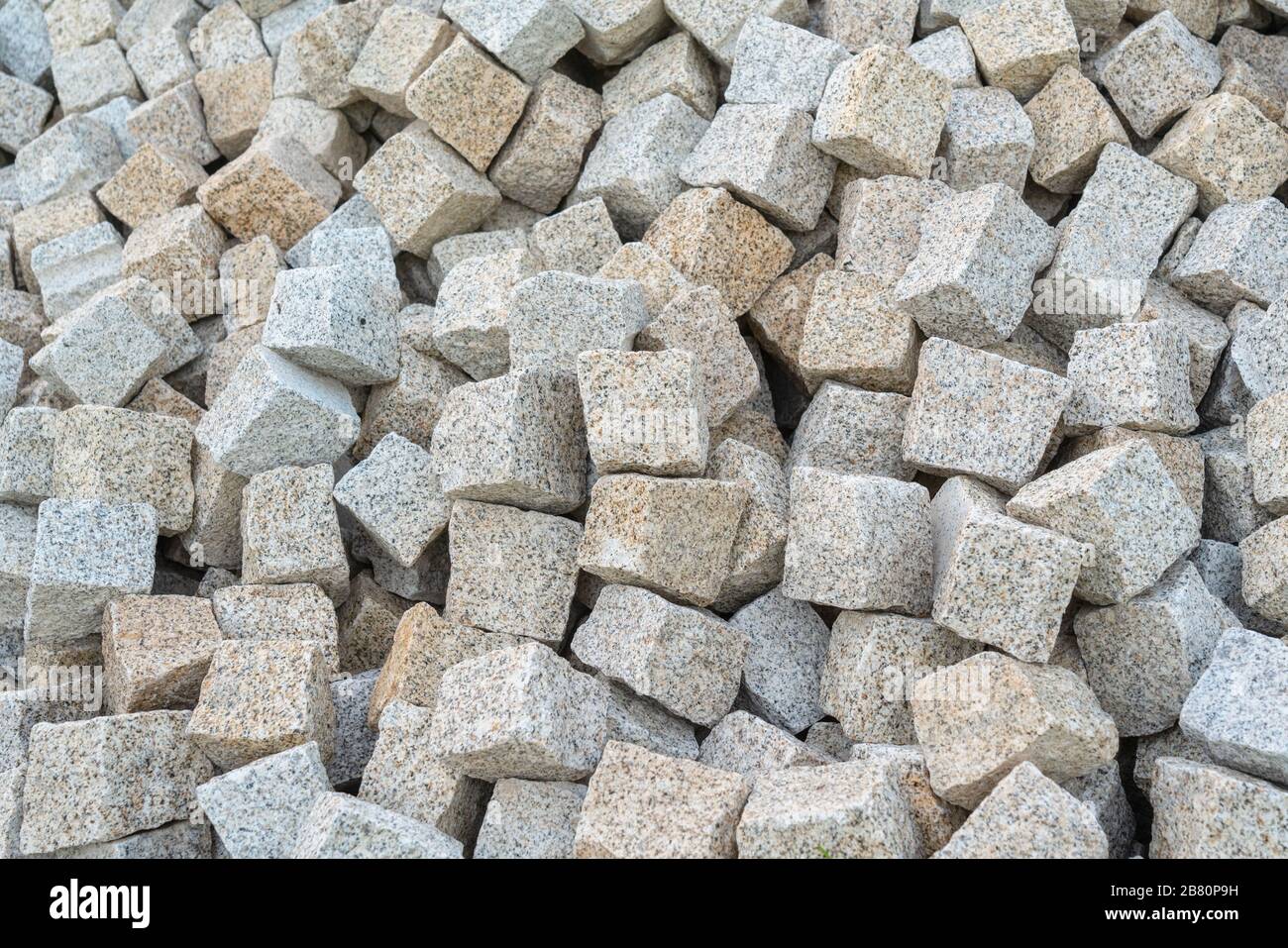 Stone paving stones, for laying the road, poured into a pile for construction work. Close-up Stock Photo