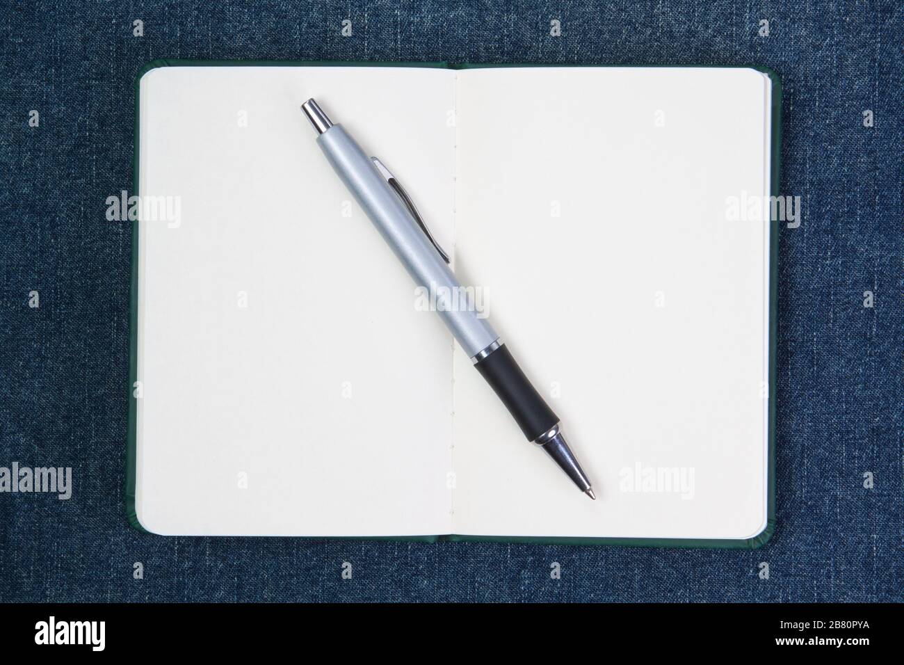 Ballpoint pen on notebook. On a blue background. Stock Photo