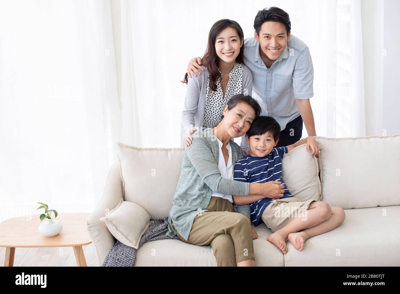 Happy Chinese family relaxing on sofa Stock Photo - Alamy