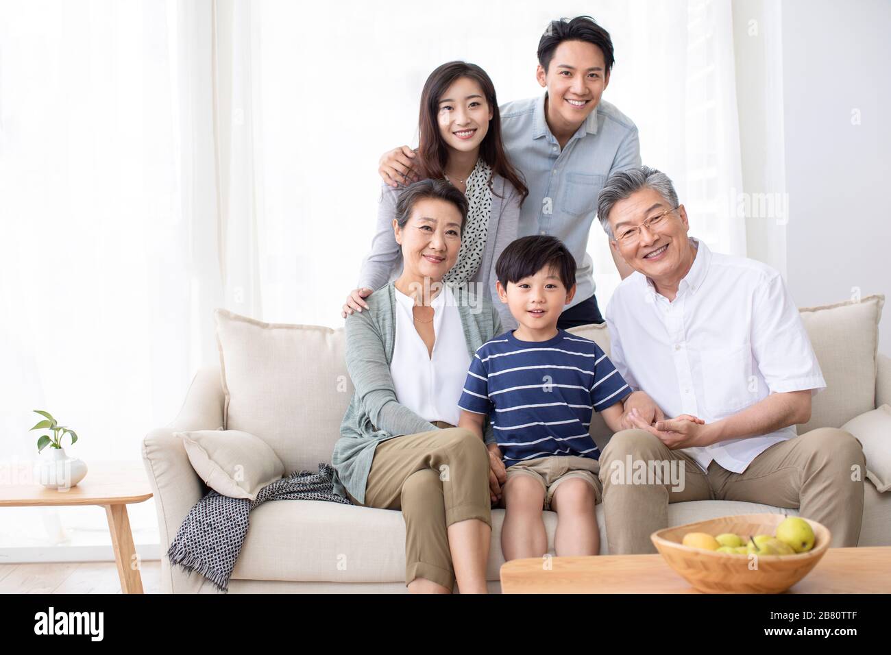 Happy Chinese family relaxing on sofa Stock Photo - Alamy
