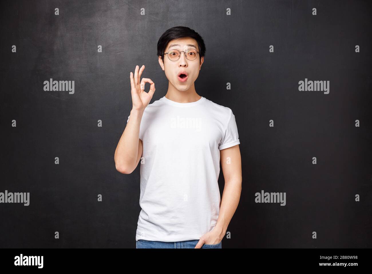 Amazed and enthusiastic young surprised asian guy left speechless and ...