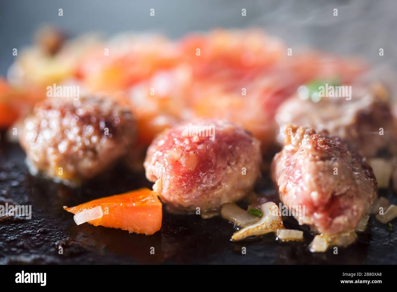 Frying meatballs with vegetables on grill, Morocco Stock Photo