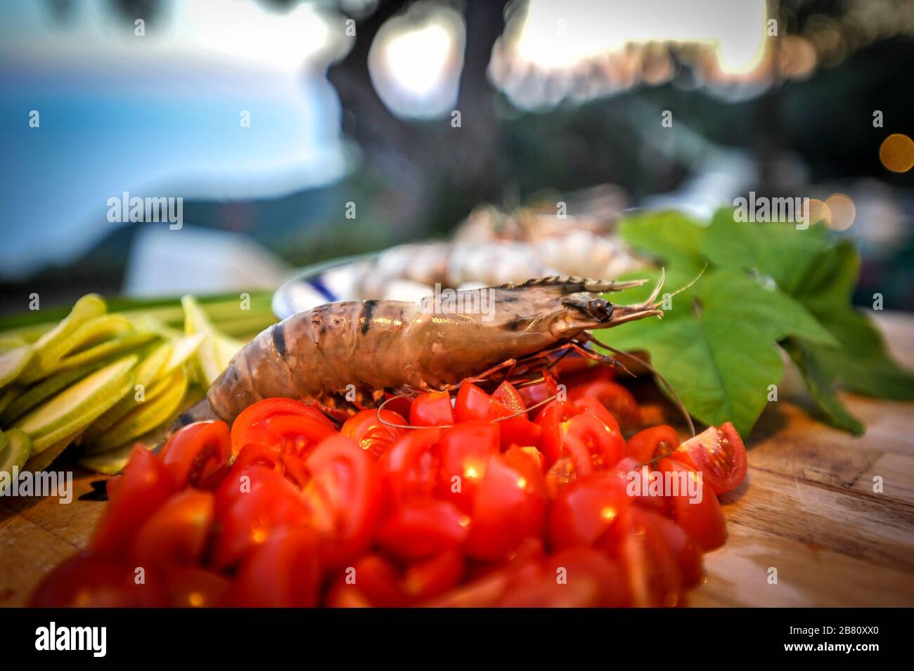 Chopped cherry tomatoes with zucchini and shrimp. Stock Photo