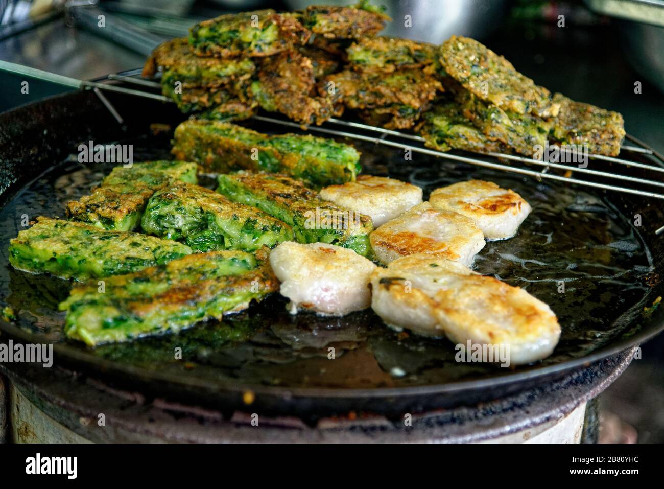 Tod Mun Pla,Thai authentic local food. Spicy fried fish cake with crispy holy basil in wicker basket. Street food in local fresh market, Bangkok - Tha Stock Photo